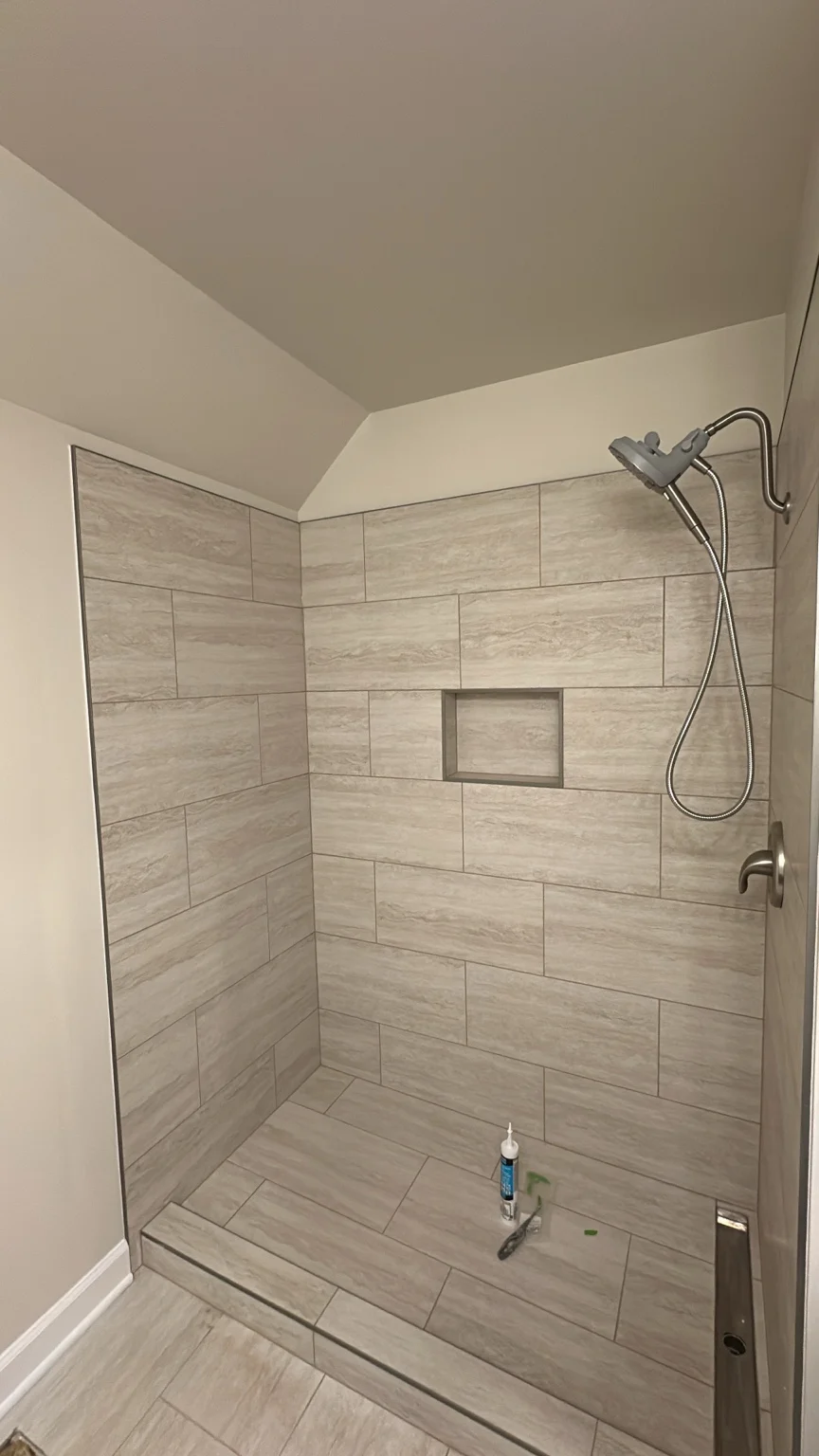 Stone-look tiled walk-in shower with recessed niche